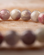Detalle macro de las cuentas de Turmalina Rosa con manchas rosas y fondo oscuro
