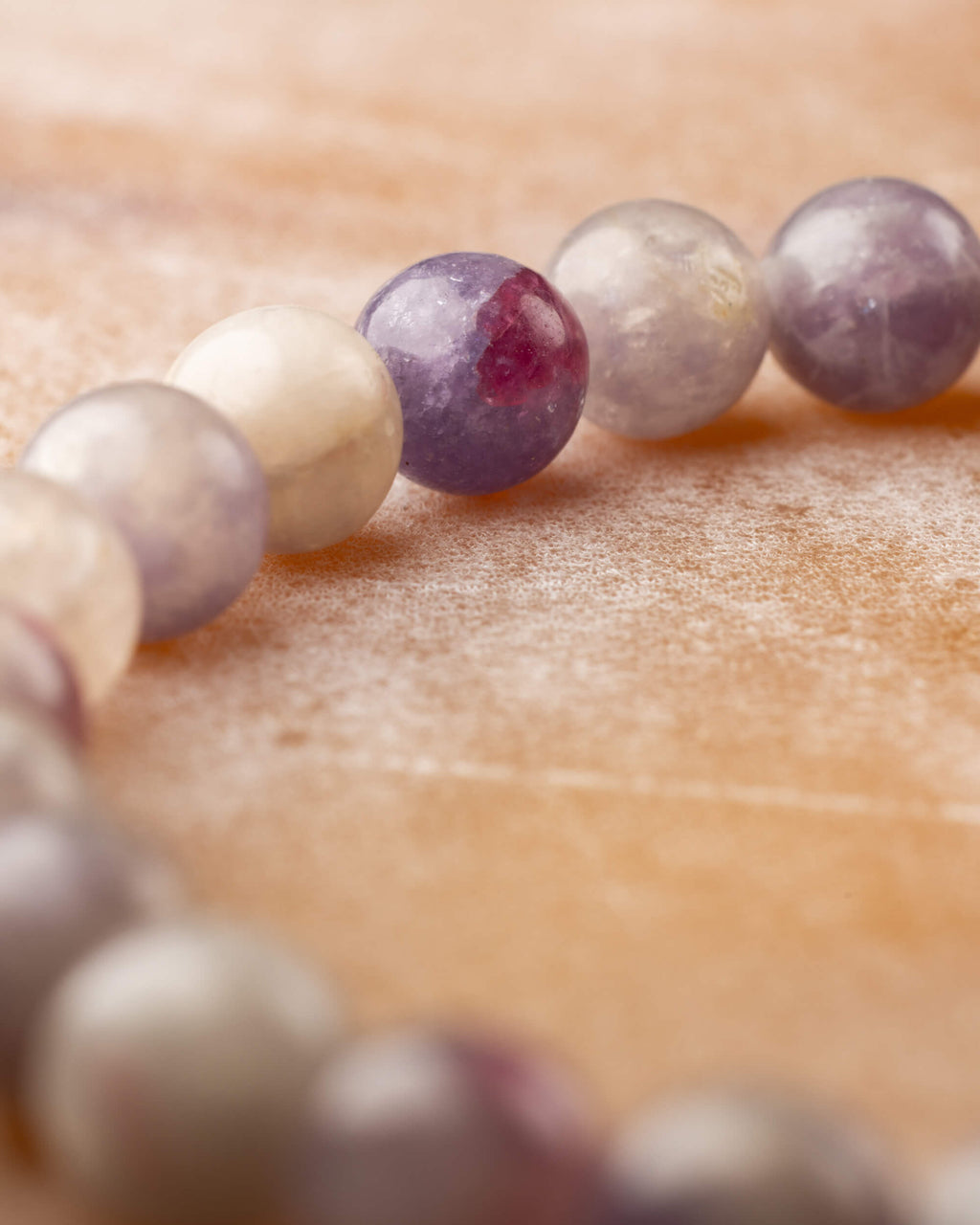 Detalle macro de las cuentas de Turmalina Rosa en tonos lavanda, crema y rosa