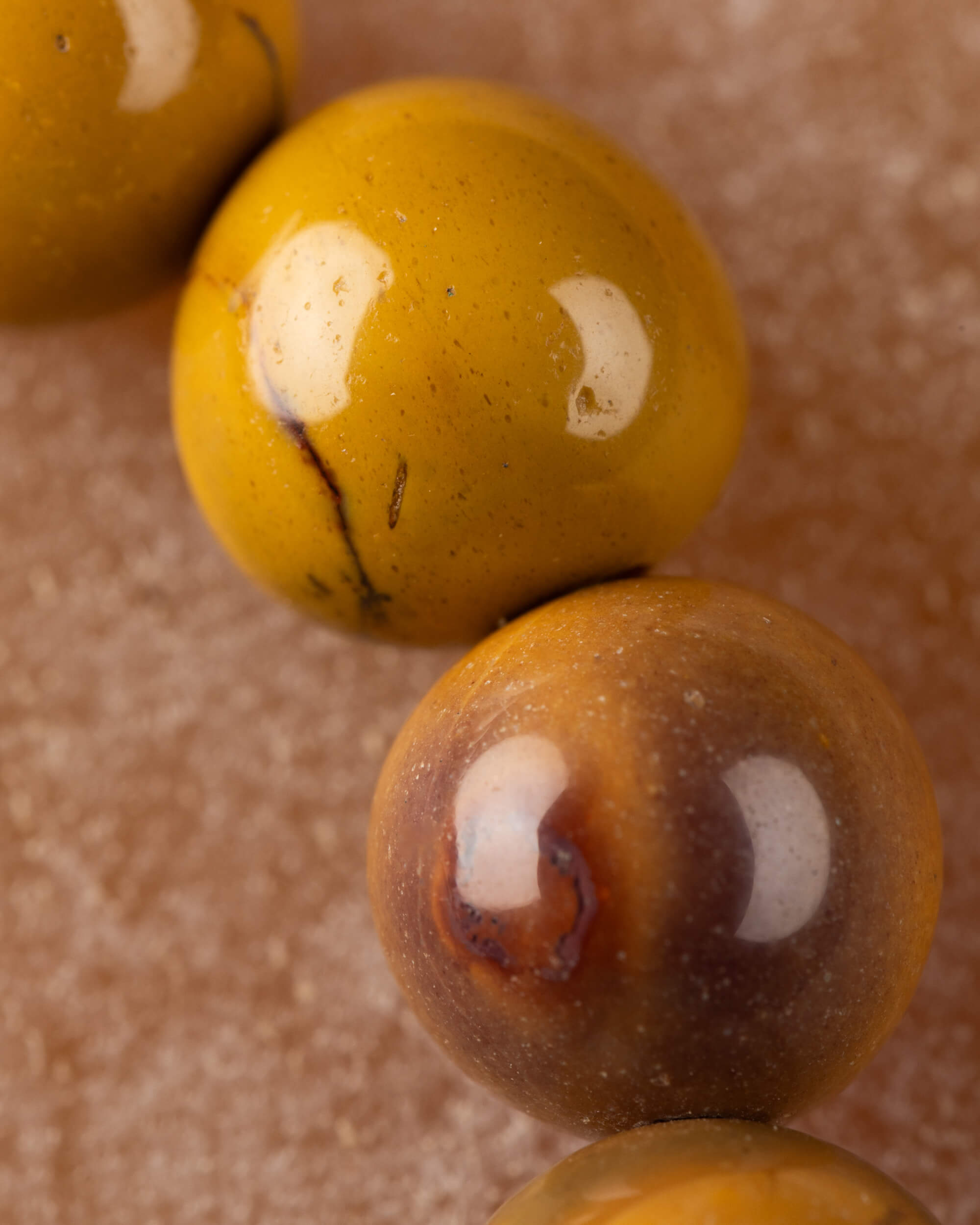 Detalle macro de cuentas amarillas de Jaspe Mokaita con manchas crema