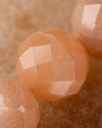 Detalle macro de una cuenta facetada de Piedra Sol Naranja con brillo dorado