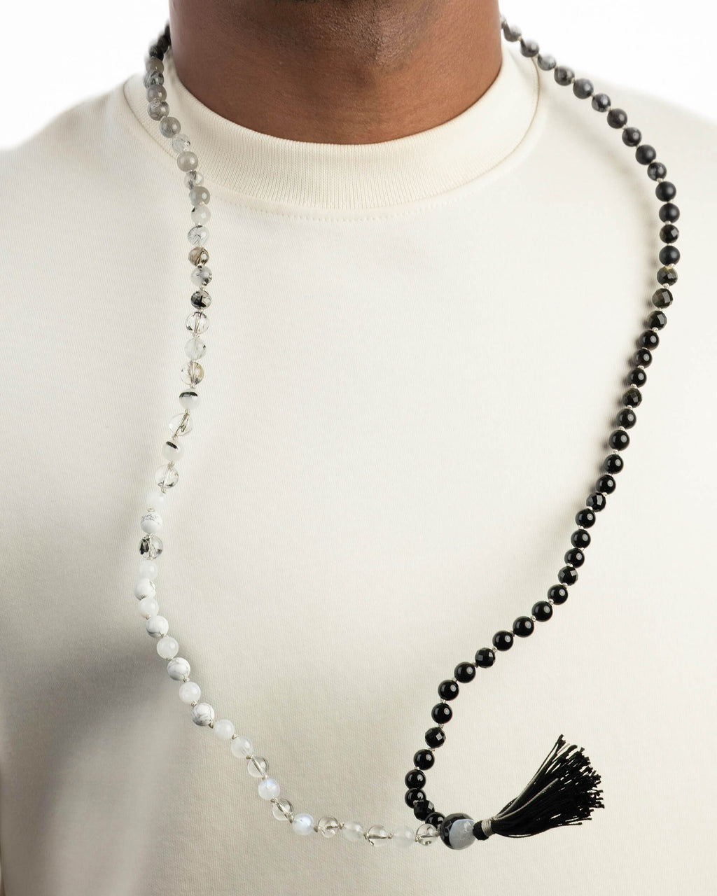 Japa Mala Dualidad puesto en el cuello, cuentas en degradado de gris a negro con borla negra