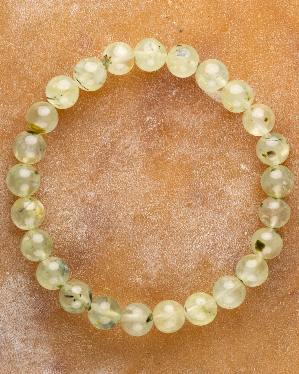 Pulsera de Prehnita de 8 mm, pieza completa en círculo sobre superficie color terracota
