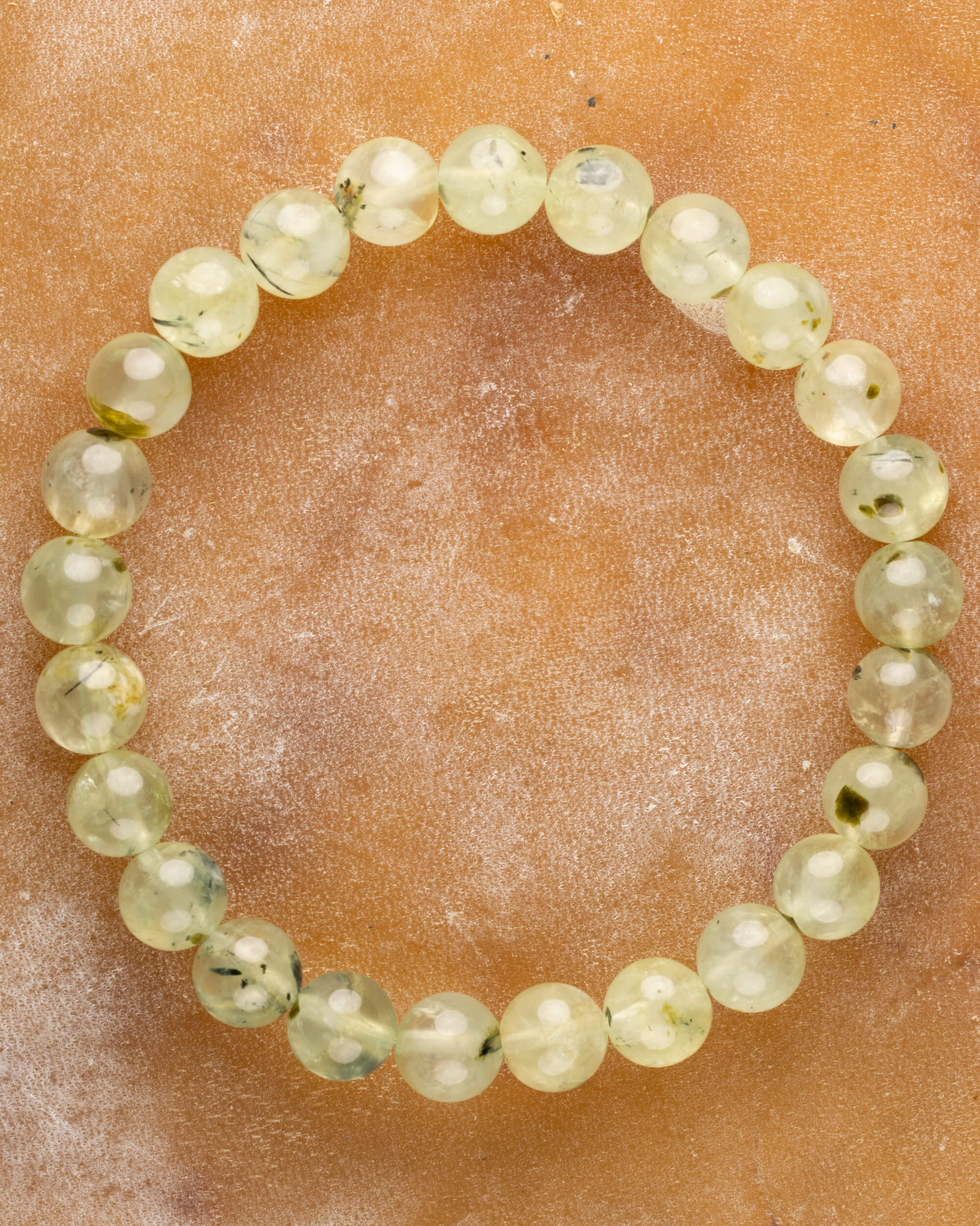 Pulsera de Prehnita de 8 mm, pieza completa en círculo sobre superficie color terracota