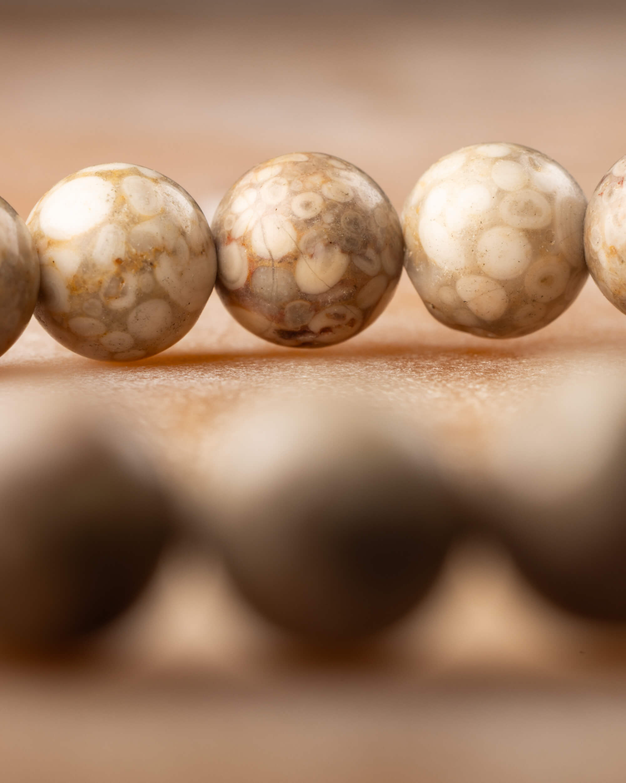 Detalle macro de las cuentas facetadas de Maifanita con vetas cafes