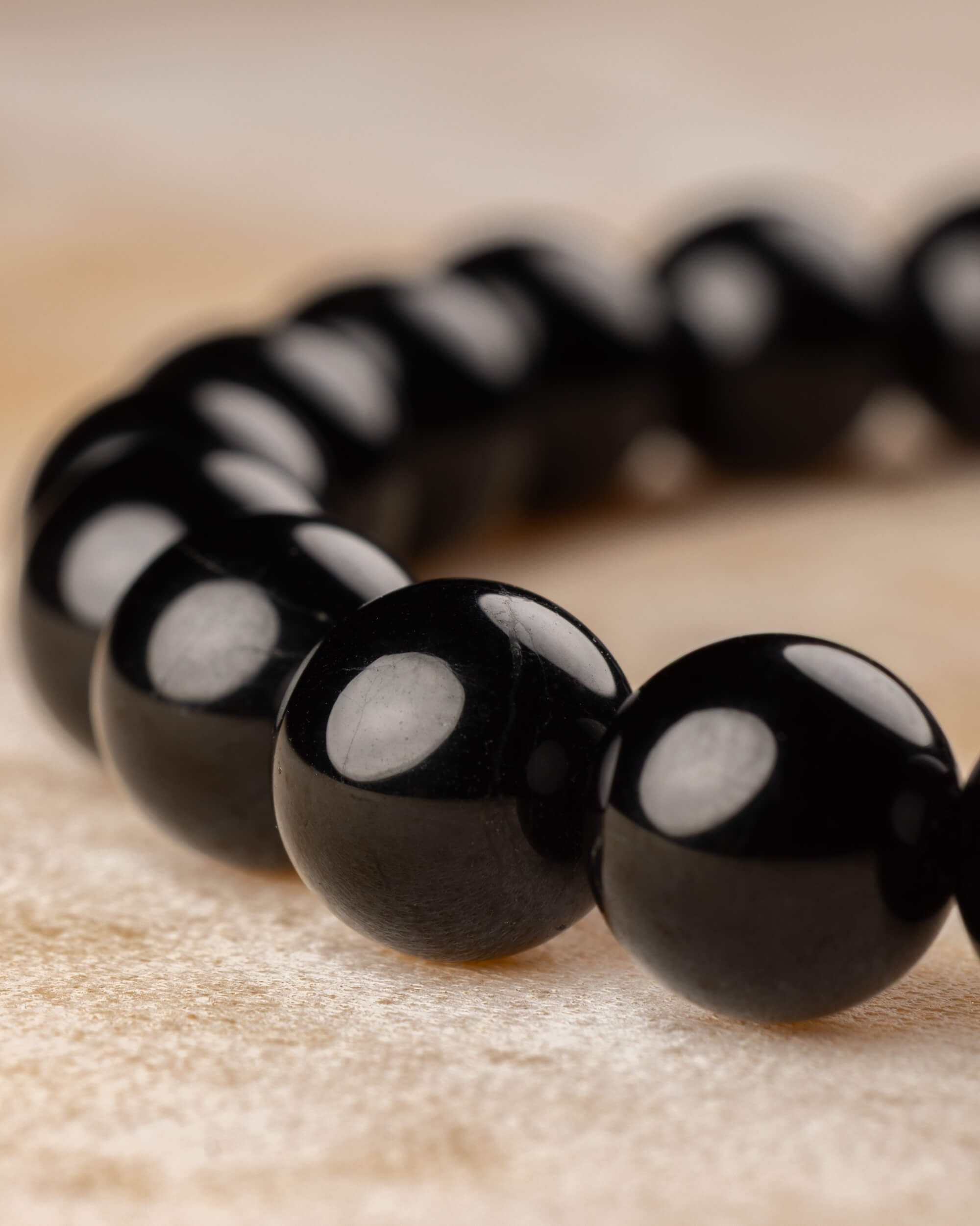 Pulsera de Turmalina Negra en curva, enfoque en las cuentas frontales