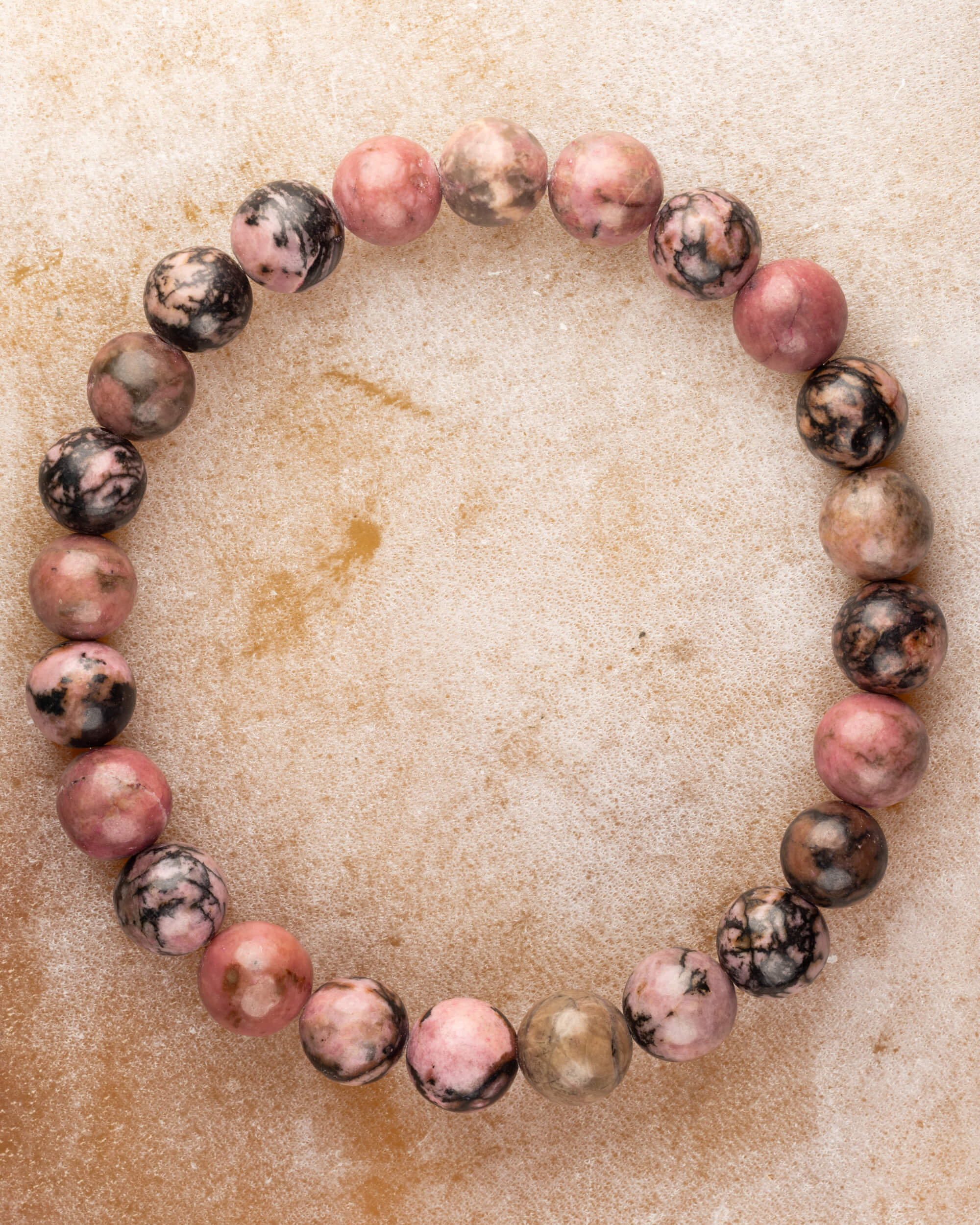 Pulsera de Rodonita Encaje Negro de 8 mm, pieza completa en círculo sobre superficie clara
