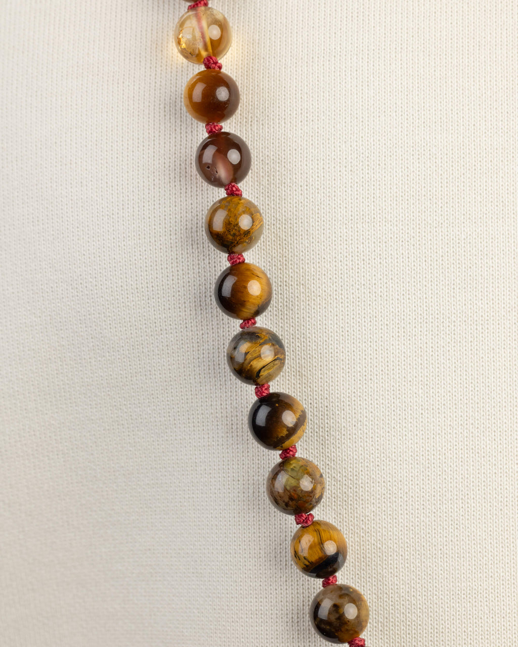 Detalle macro de cuentas de Ojo de Tigre del Japa Mala Fuego