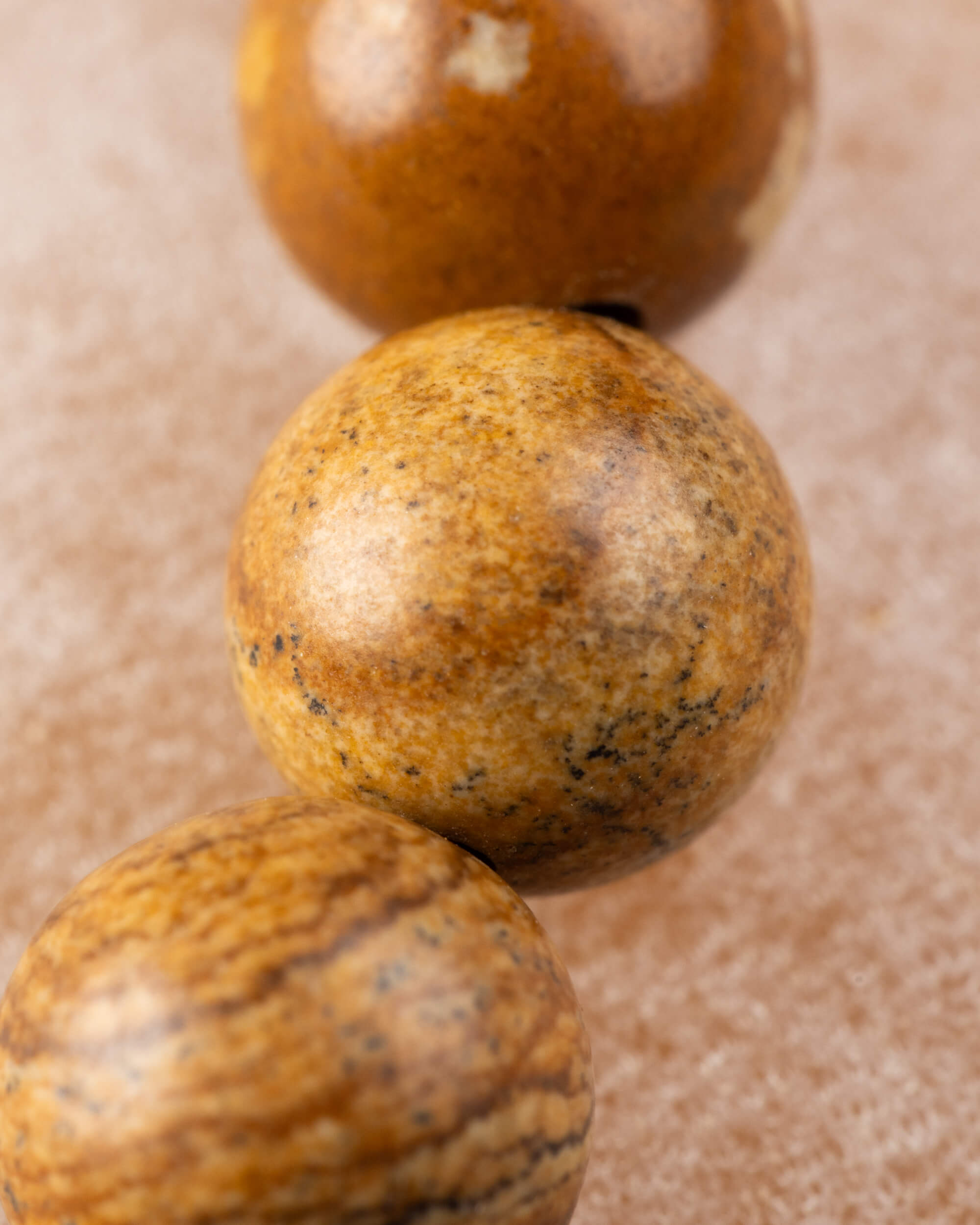 Detalle macro de las cuentas de Jaspe Paisaje con vetas cafés y doradas