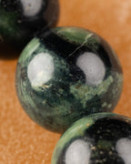 Detalle macro de una cuenta de Jaspe Kambaba con patrón verde y negro
