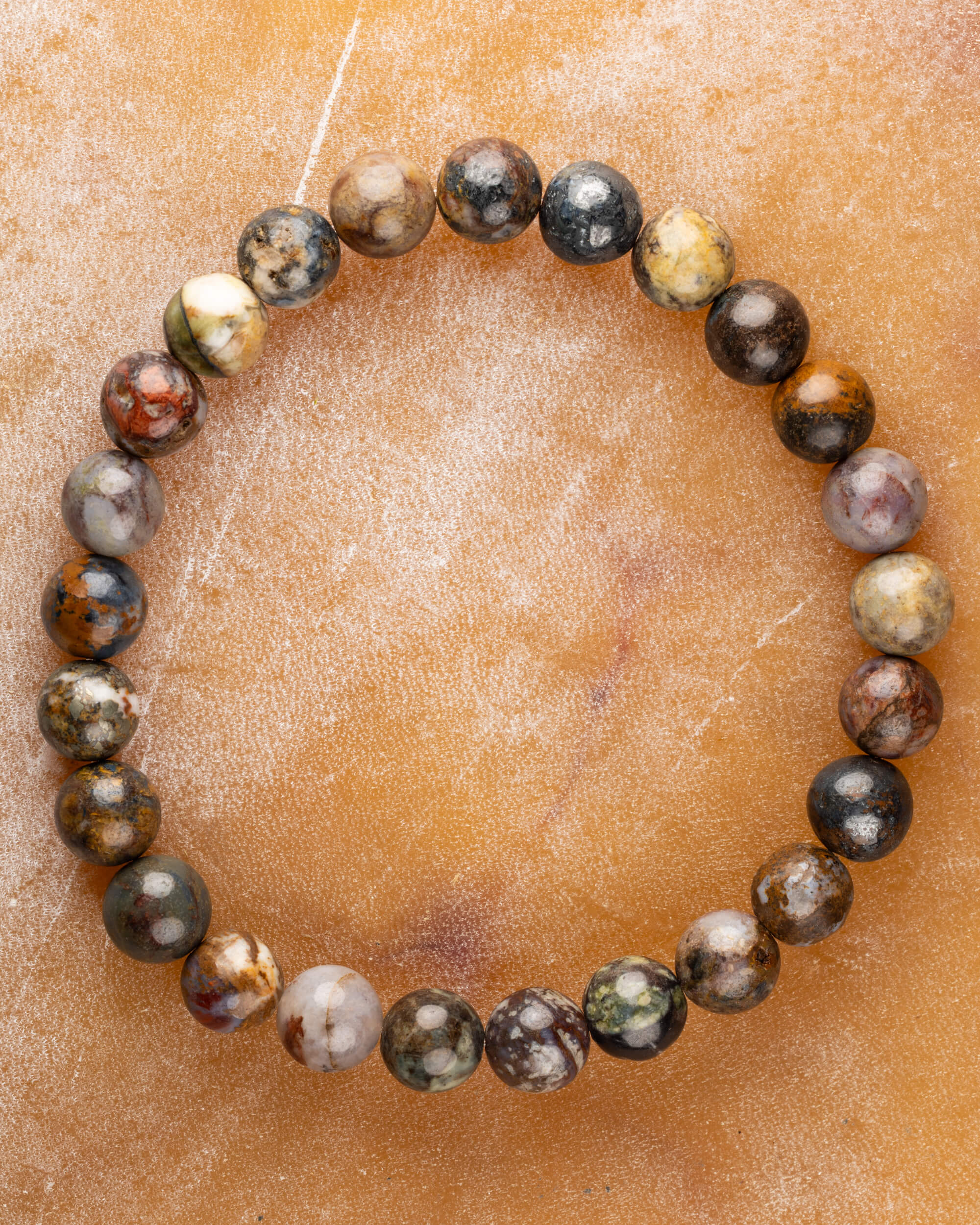 Pulsera de Pietersita multicolor de 8 mm, pieza completa en círculo sobre superficie miel