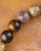 Detalle macro de cuentas de Pietersita con tonos café, gris azulado y beige