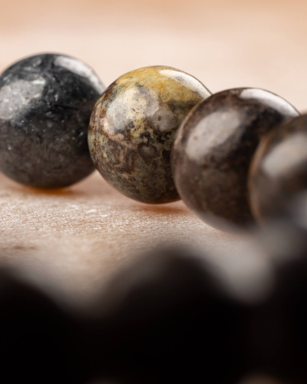 Detalle macro de cuentas de Pietersita con vetas negras, doradas y cafés