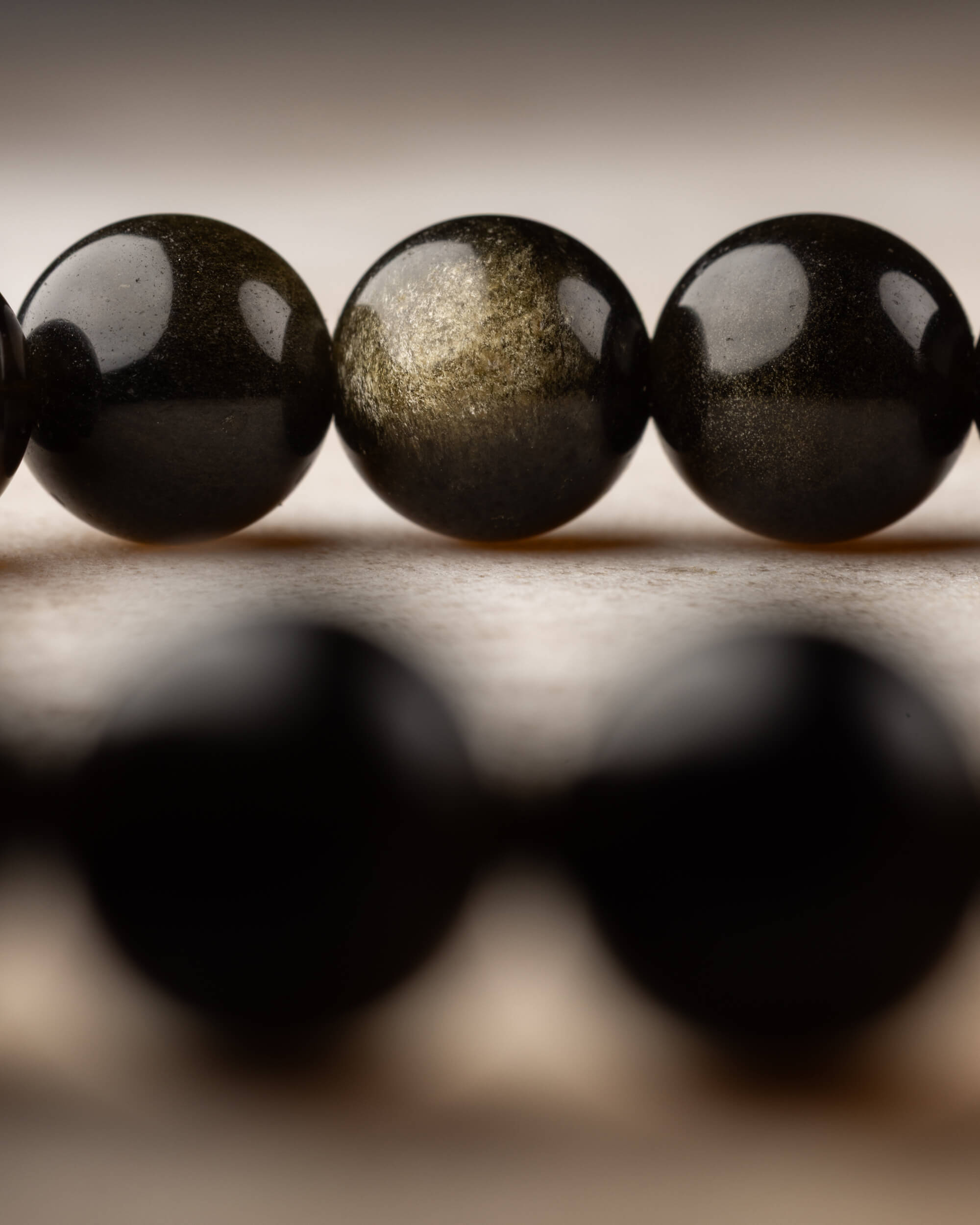 Pulsera de Obsidiana Dorada con doble hilera, reflejo dorado en primer plano