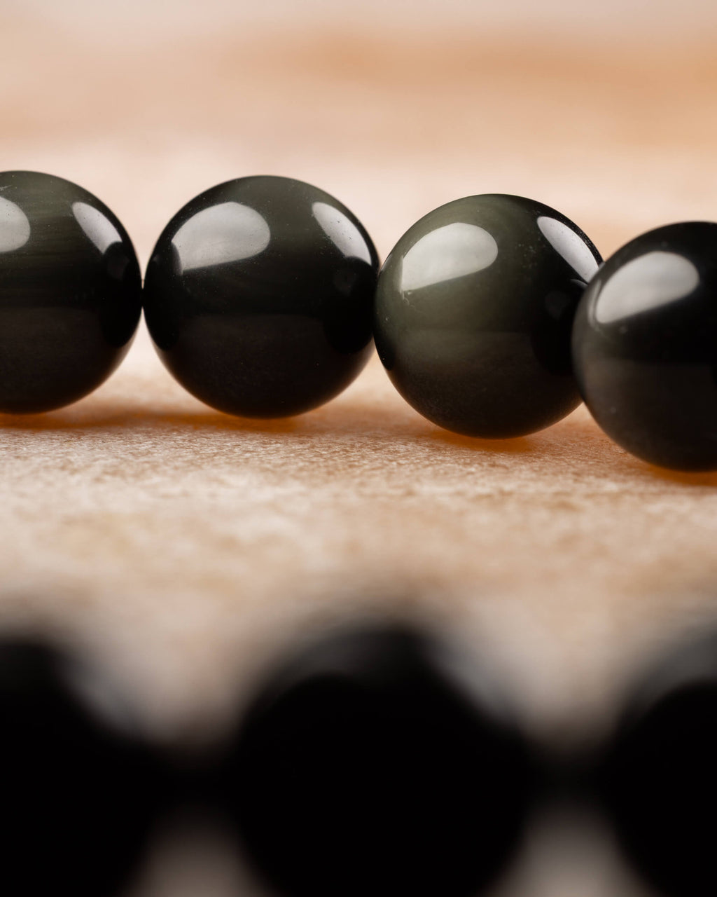 Pulsera de Obsidiana Arcoíris en ángulo bajo, doble hilera de cuentas visibles