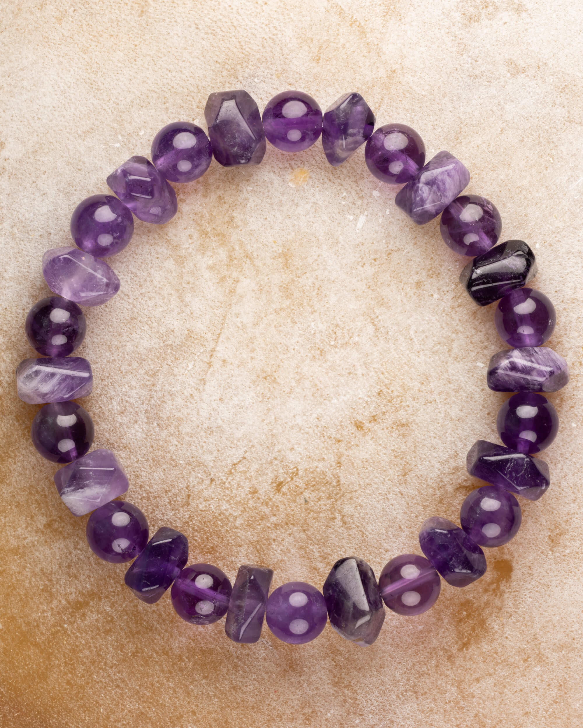 Pulsera de Amatista, pieza completa en círculo sobre superficie color arena