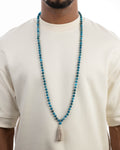 Japa Mala de Apatita Azul puesto, cayendo sobre el pecho con playera clara