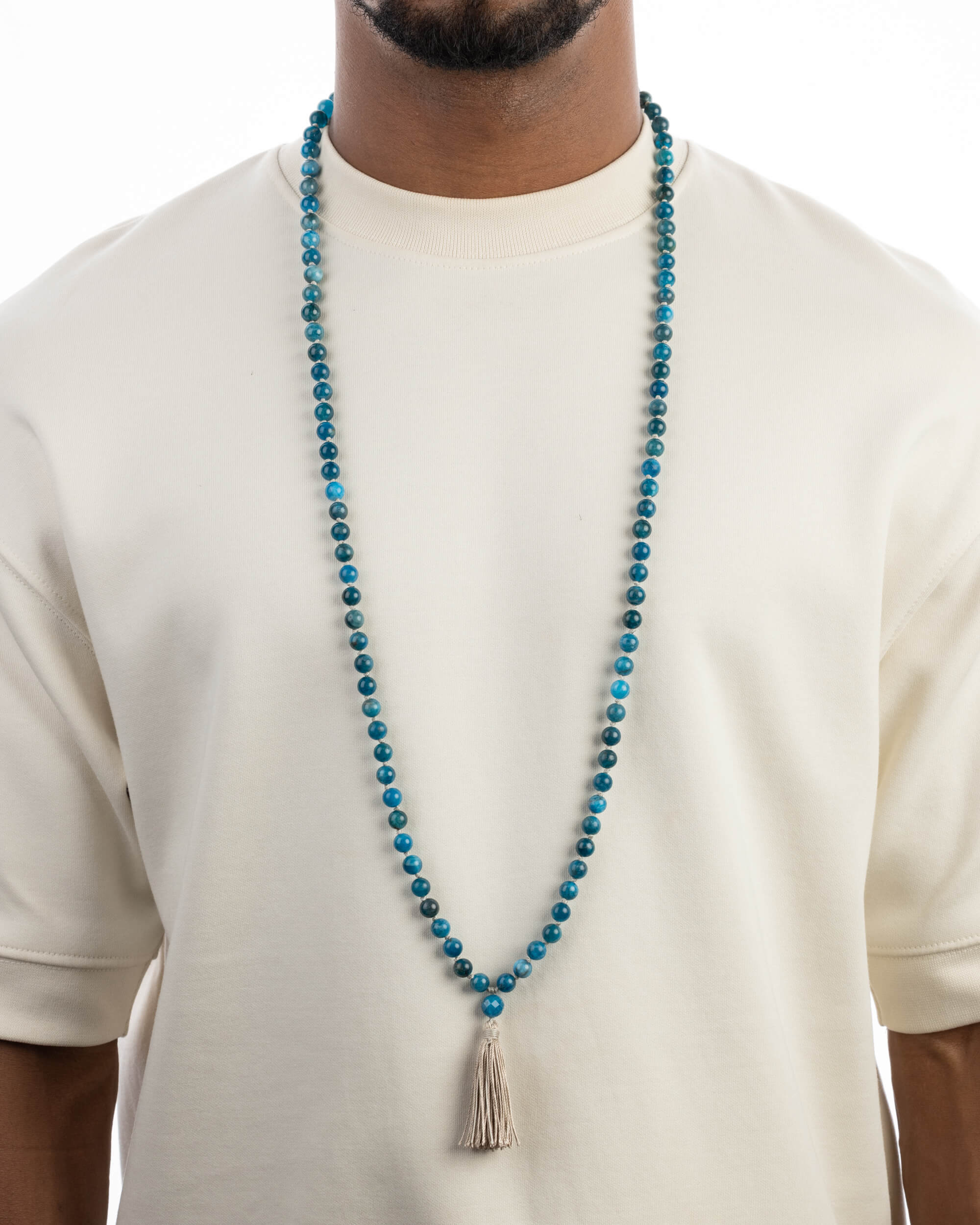 Japa Mala de Apatita Azul puesto, cayendo sobre el pecho con playera clara