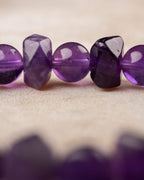 Detalle macro de cuentas de Amatista facetadas y redondas con brillo morado