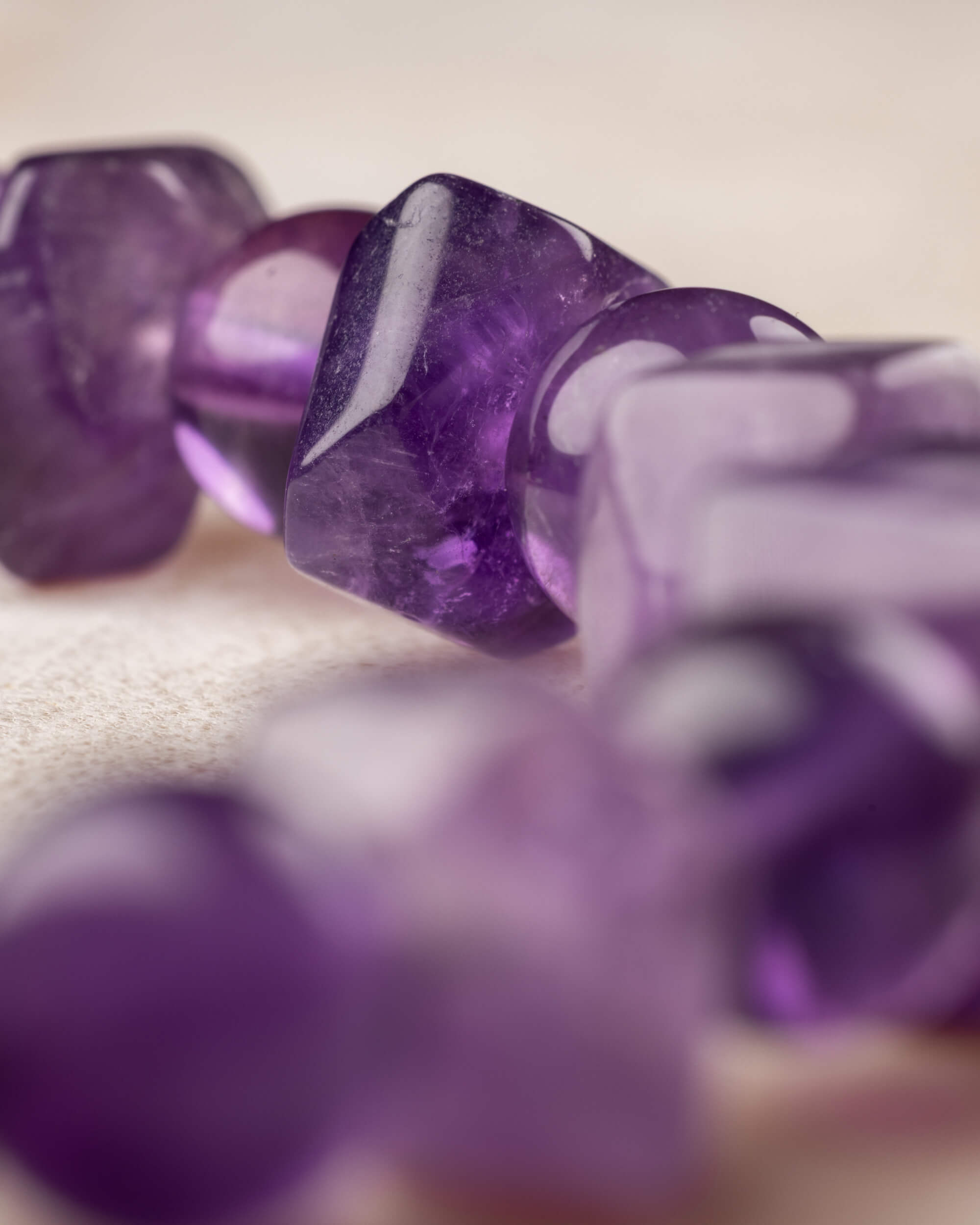 Detalle macro de cuentas facetadas de Amatista con tono morado profundo