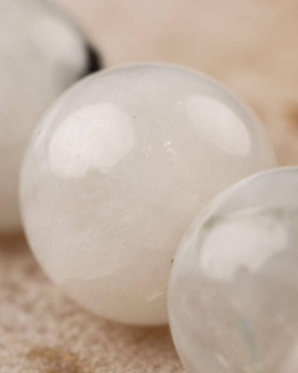 Detalle macro de una cuenta de Piedra Luna con brillo azulado