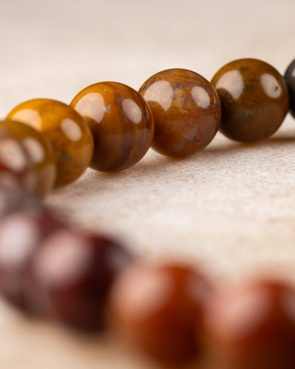 Pulsera de Jaspe Oceánico vista de lado con degradado de ocre a rojo oscuro