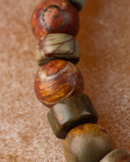 Detalle macro de cuentas de Jaspe Picasso con disco crema y esfera ocre veteada
