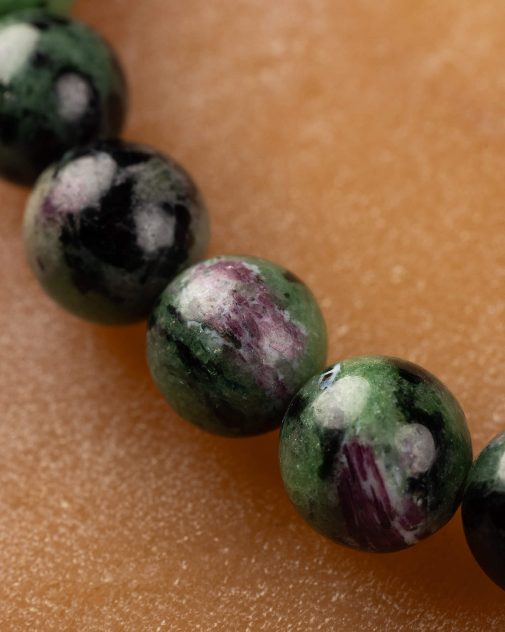 Macro de cuentas de Zoisita verdes con vetas rosadas y negras de la pulsera