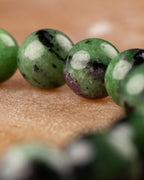 Macro de cuentas de Zoisita verdes con manchas negras y blancas de la pulsera
