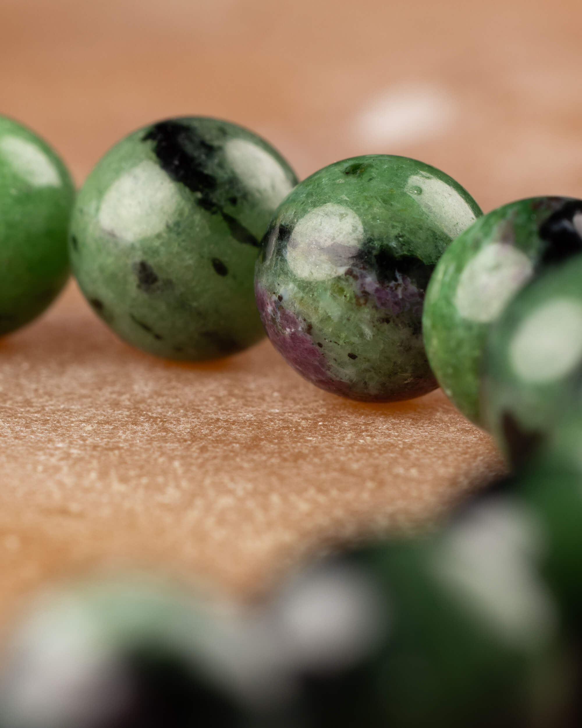 Macro de cuentas de Zoisita verdes con manchas negras y blancas de la pulsera