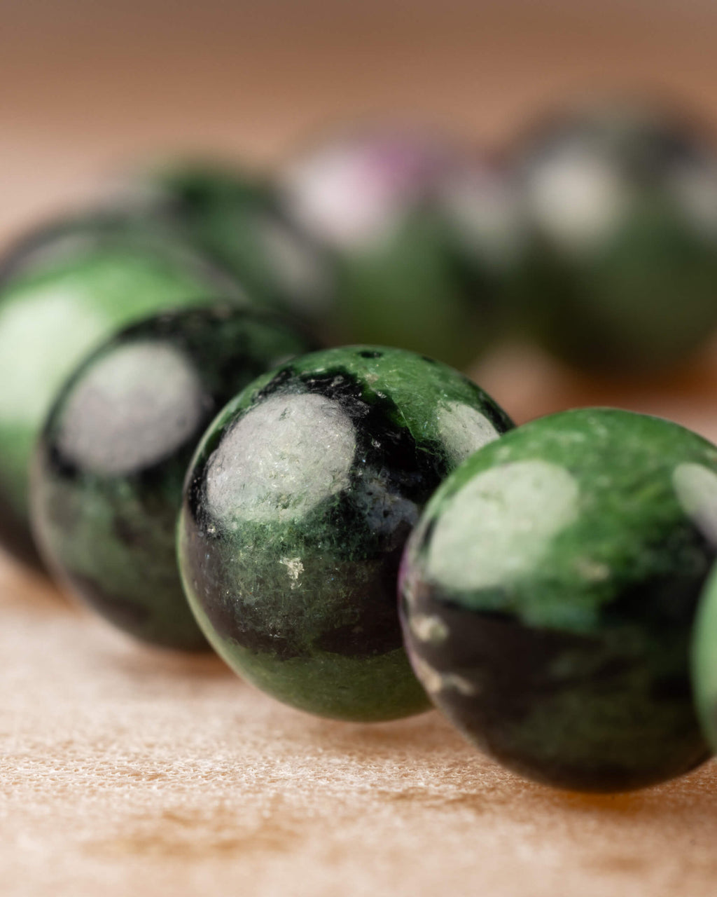 Perspectiva de la pulsera de Zoisita con cuentas verdes, negras y vetas rosadas