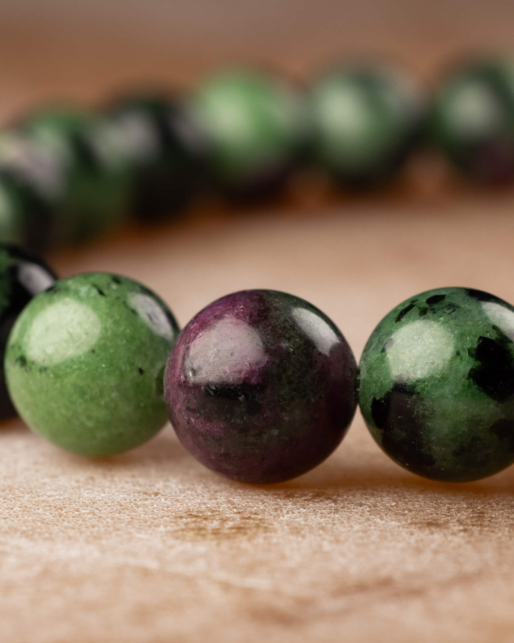 Perspectiva de la pulsera de Zoisita, cuenta con veta rosada entre cuentas verdes