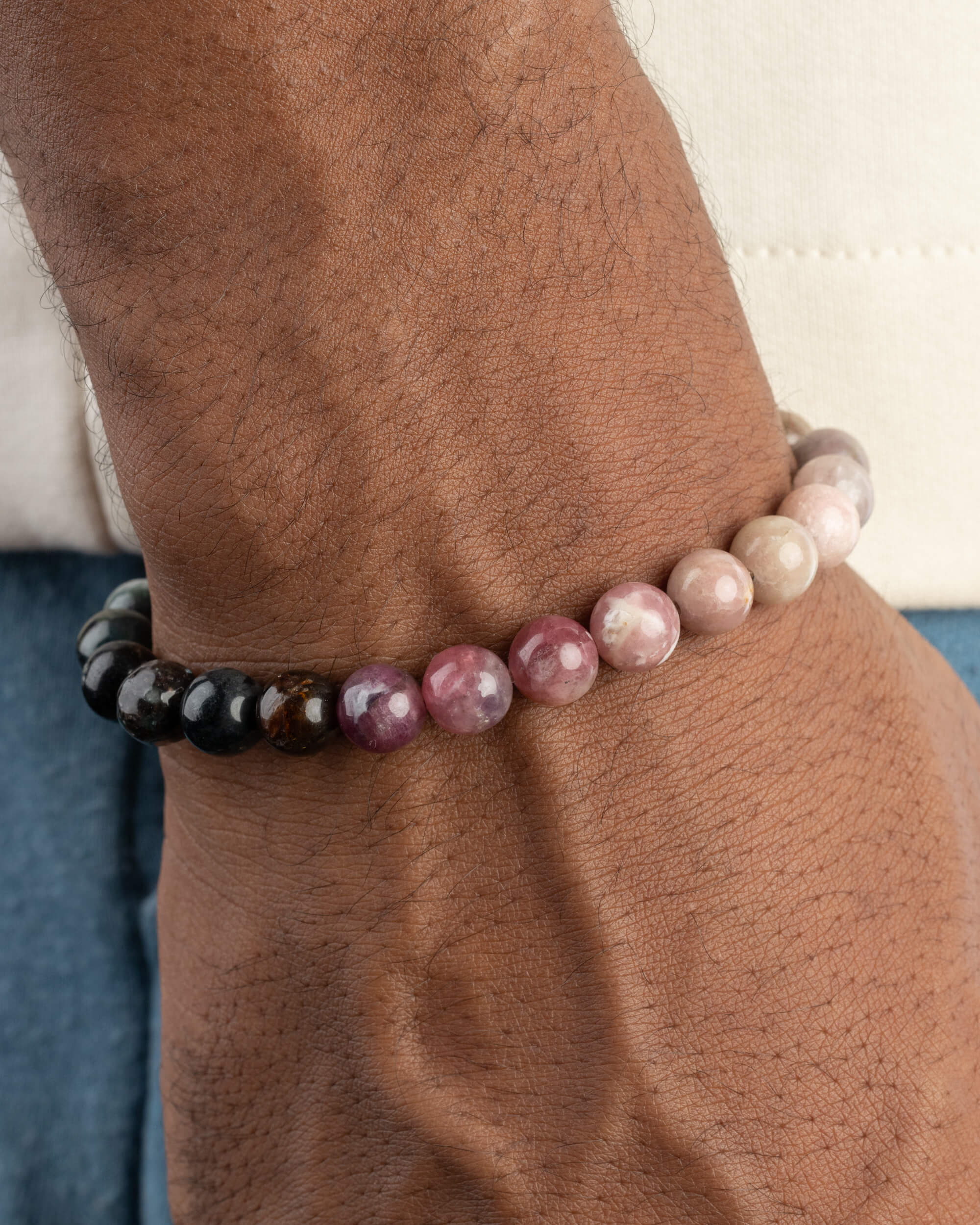 Pulsera de Turmalina Multicolor puesta en la muñeca, con tonos negros, rosas y verdes visibles