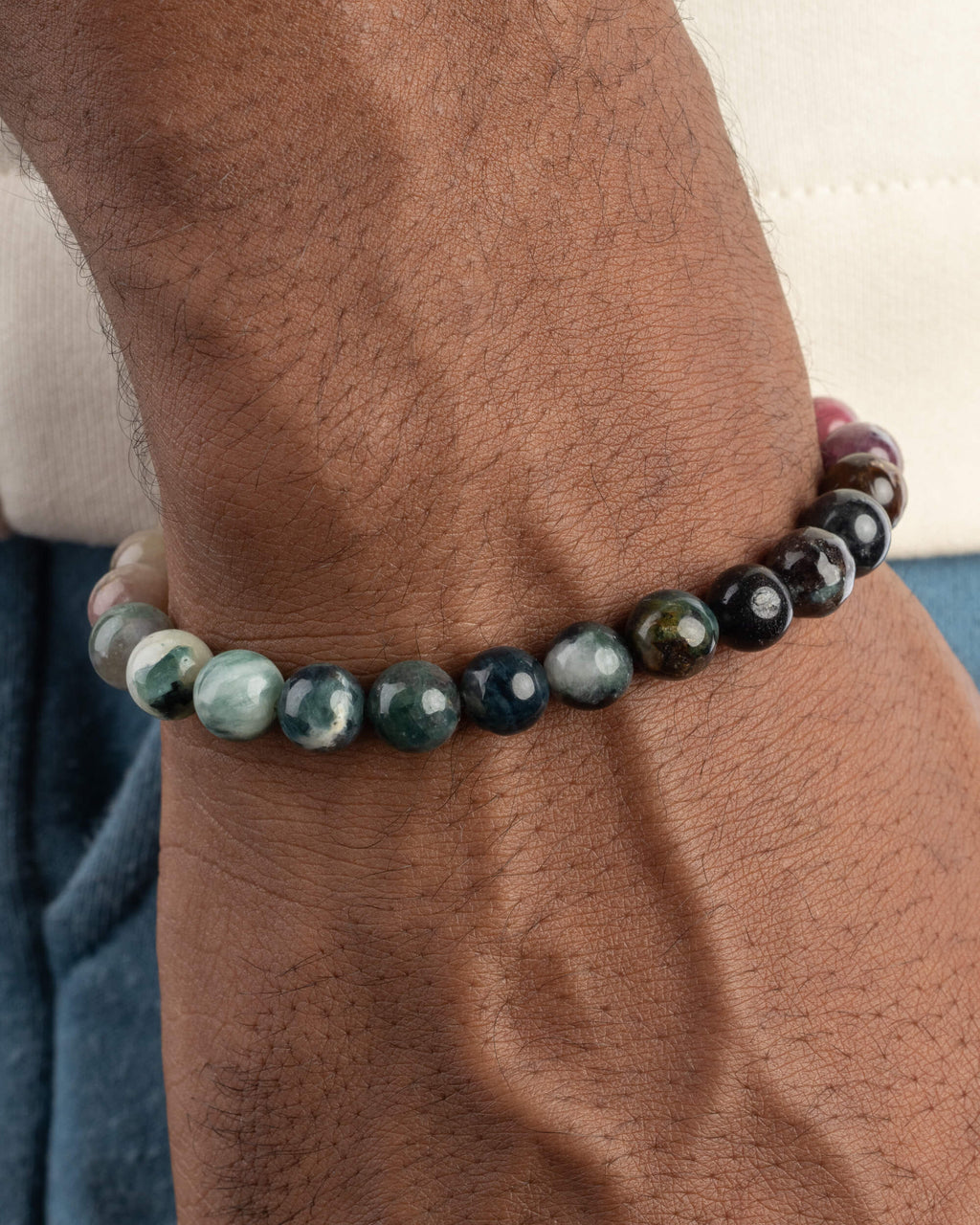Pulsera de Turmalina Multicolor puesta en la muñeca, mostrando el tramo de tonos verdes y negros
