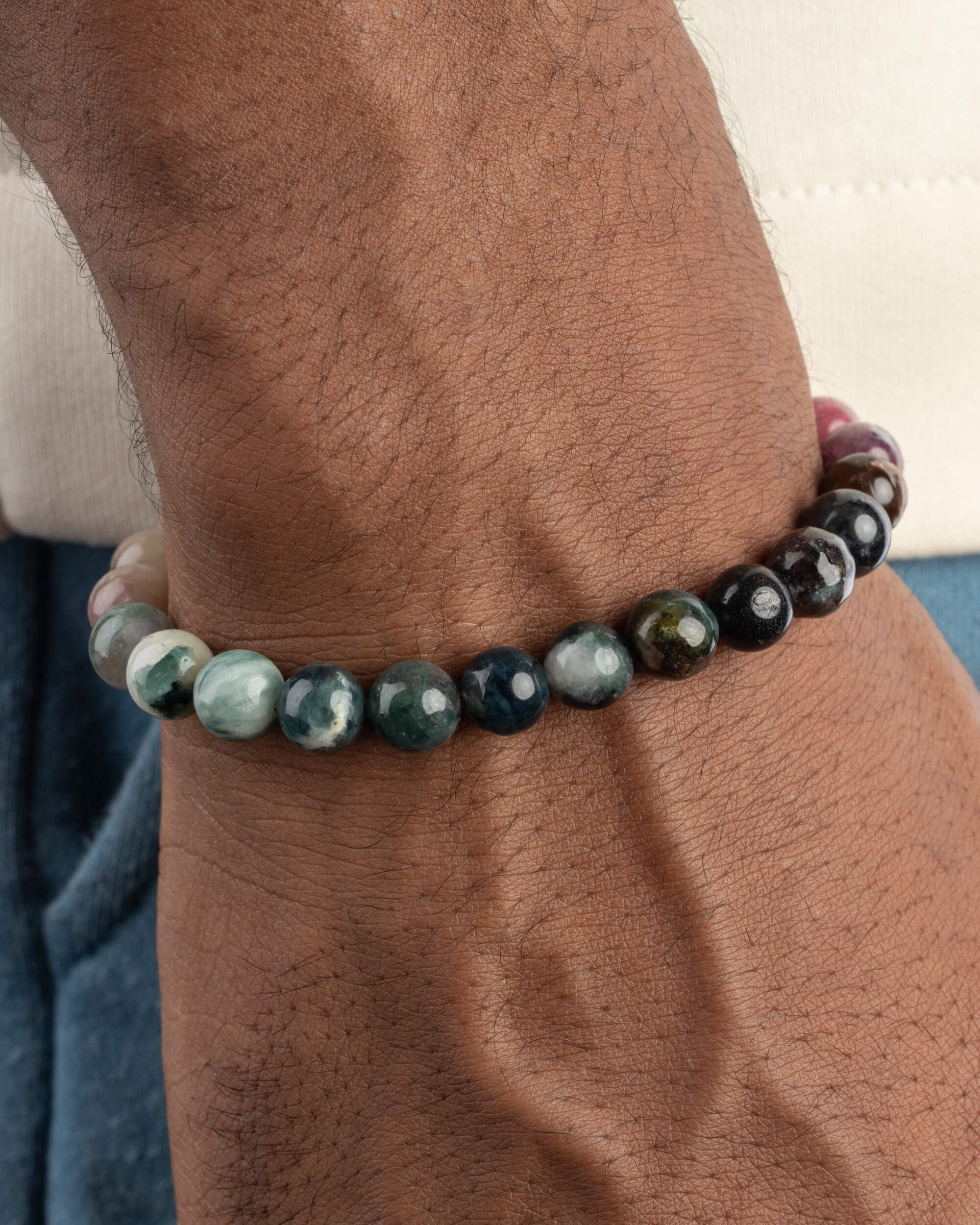 Pulsera de Turmalina Multicolor puesta en la muñeca, mostrando el tramo de tonos verdes y negros