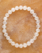 Pulsera de la Piedra Luna de 7 mm, pieza completa en círculo sobre superficie color miel