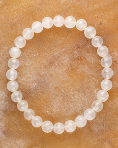 Pulsera de la Piedra Luna de 7 mm, pieza completa en círculo sobre superficie color miel
