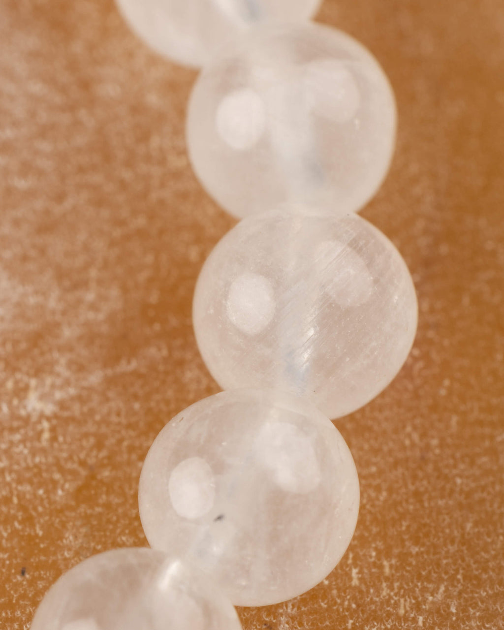 Detalle macro vertical de cuentas de la Piedra Luna con reflejos blancos y azulados