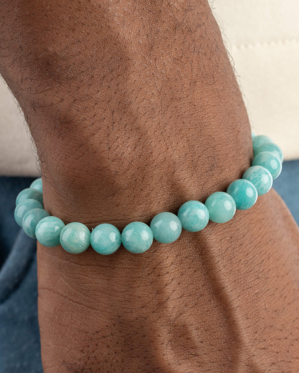 Pulsera de Amazonita Aqua puesta en la muñeca, con mezclilla azul al fondo