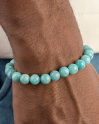 Pulsera de Amazonita Aqua puesta en la muñeca, con mezclilla azul al fondo