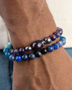 Codificador Universo puesto en la muñeca junto a otra pulsera, tonos azules y morados