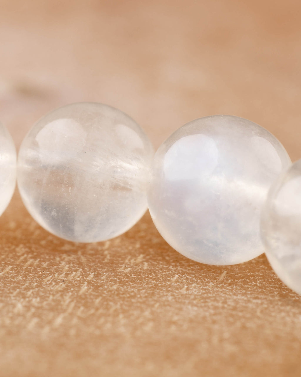 Detalle macro de cuentas de la Piedra Luna con brillo blanco y transparencia suave