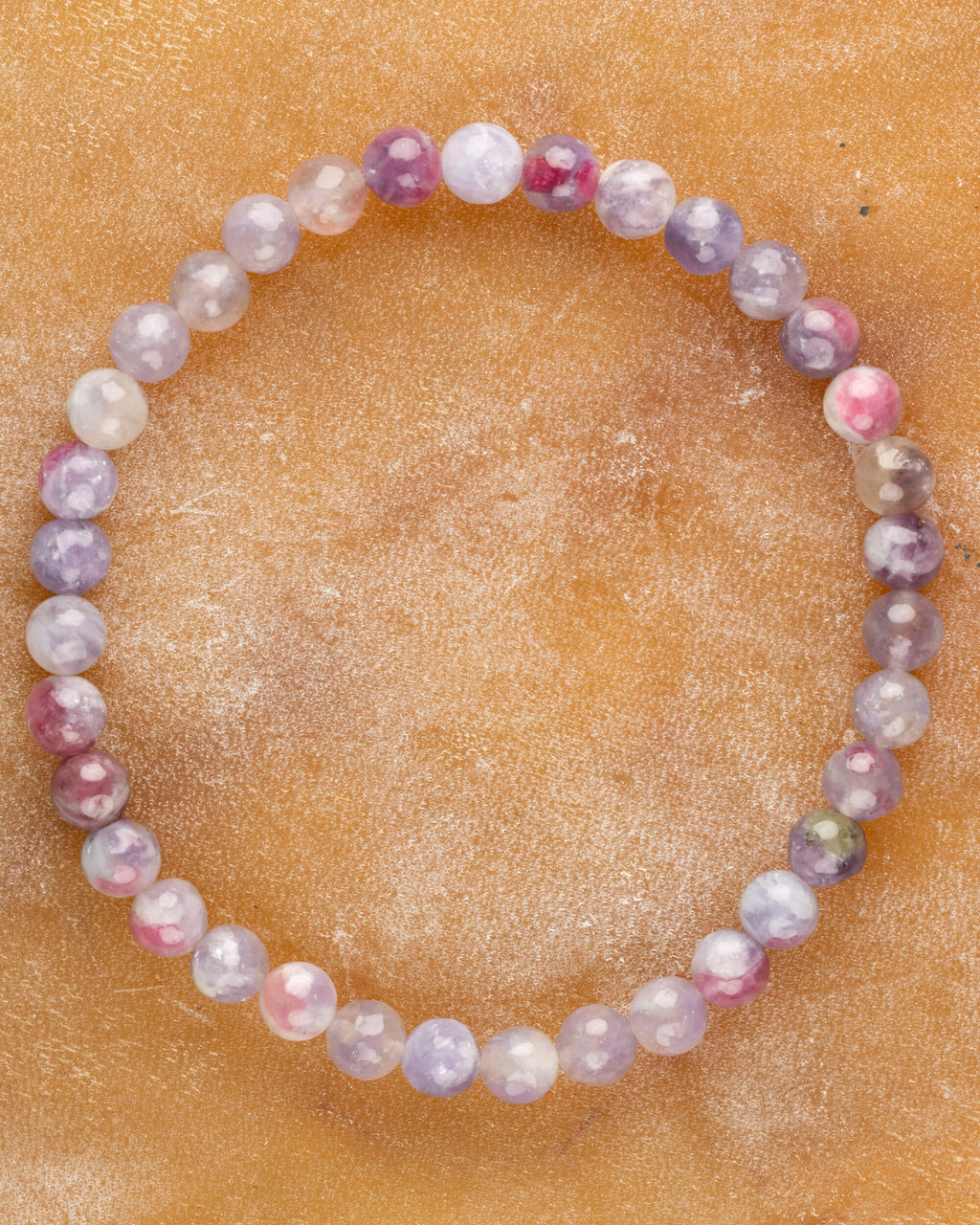 Pulsera de Turmalina Rosa de 6 mm, pieza completa en círculo sobre superficie ambar