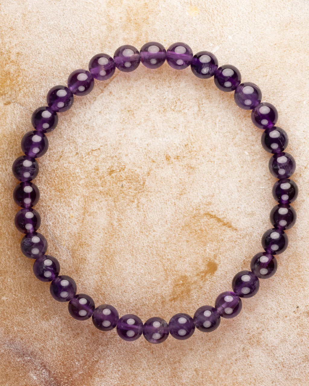 Pulsera de Amatista de 6 mm, pieza completa en círculo sobre superficie clara
