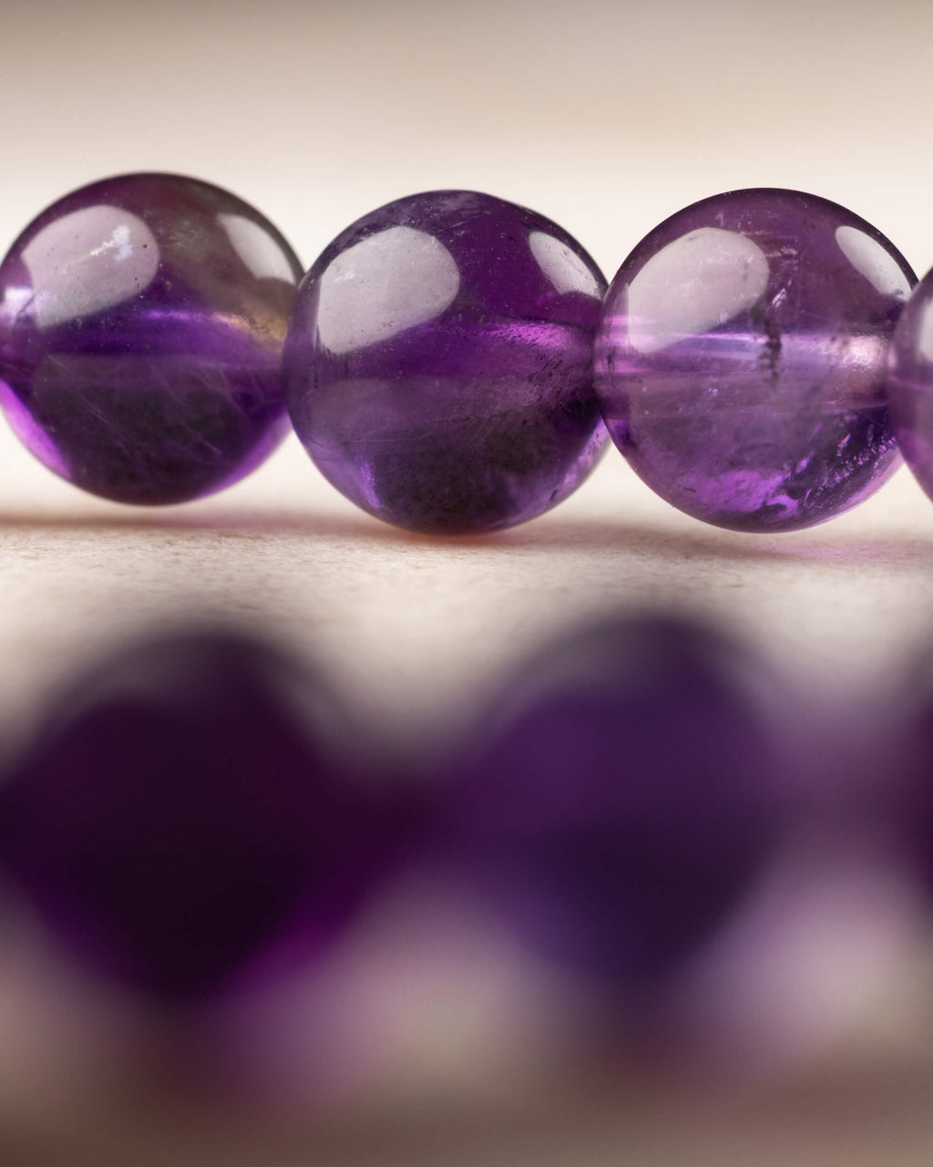 Cuentas de Amatista en primer plano con tonos violeta y reflejos de luz