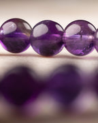 Cuentas de Amatista en primer plano con tonos violeta y reflejos de luz