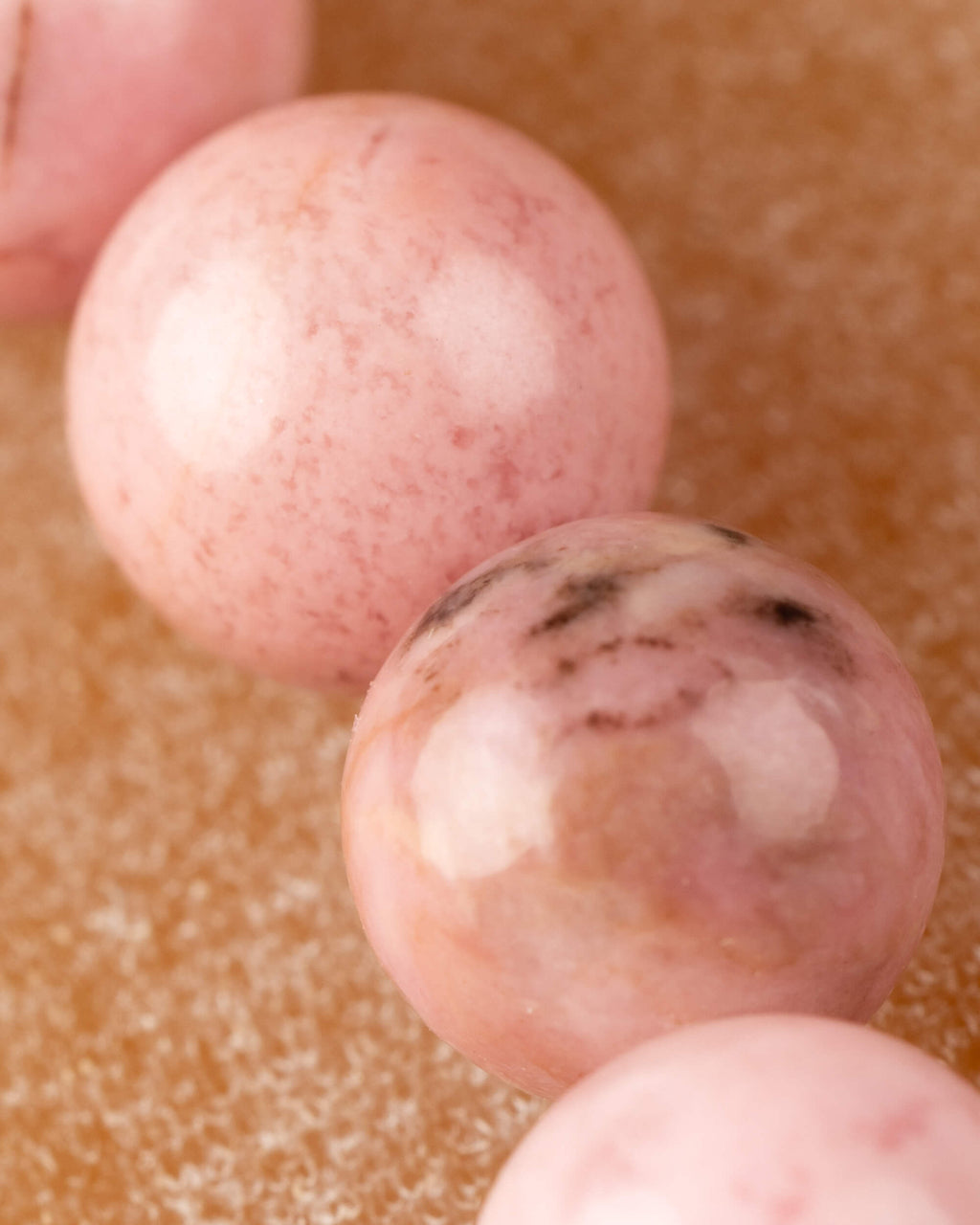 Detalle macro de cuentas de Rodonita Rosa con manchas blancas redondas