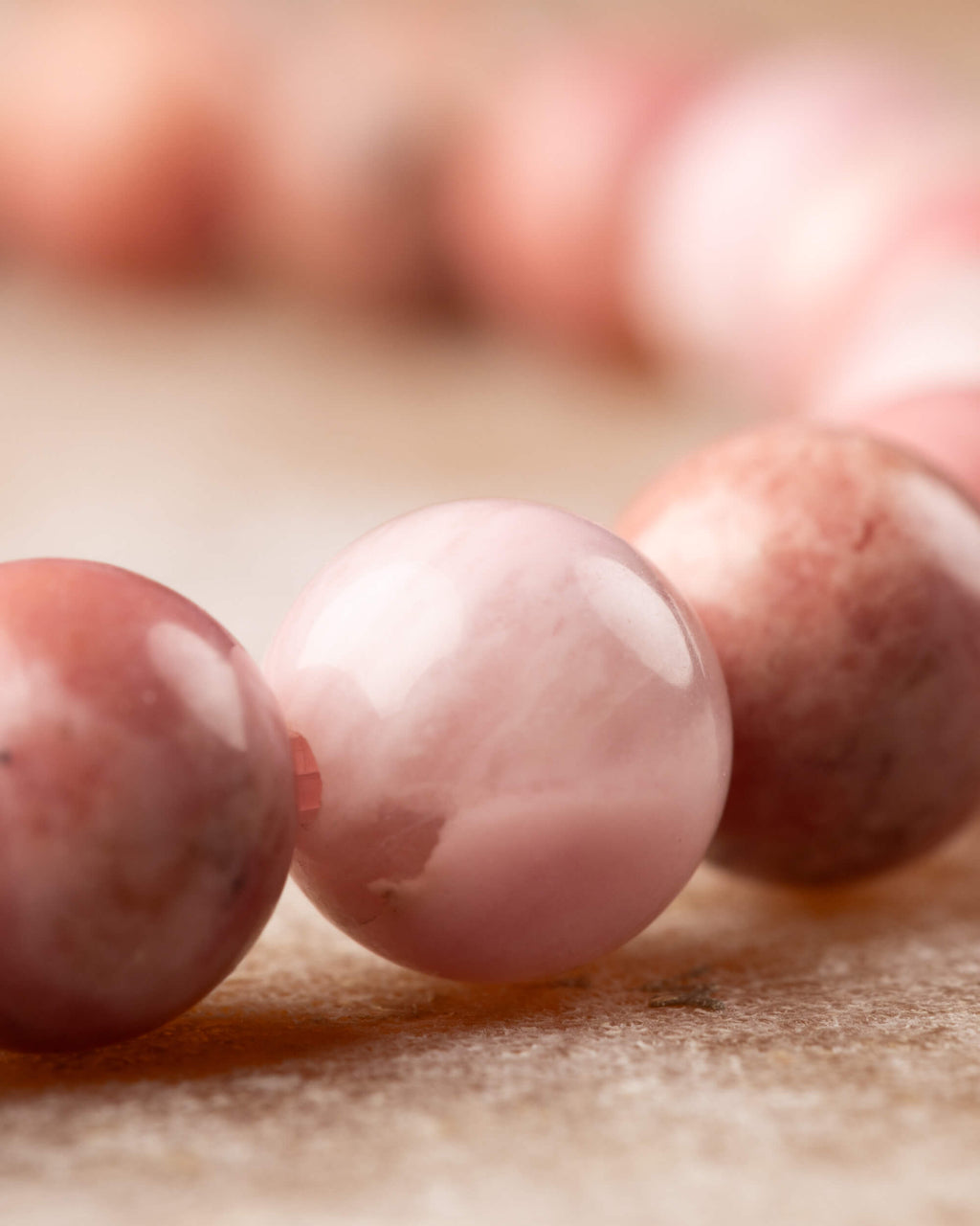 Detalle macro de cuentas de Rodonita Rosa con tonos rosa pálido y coral