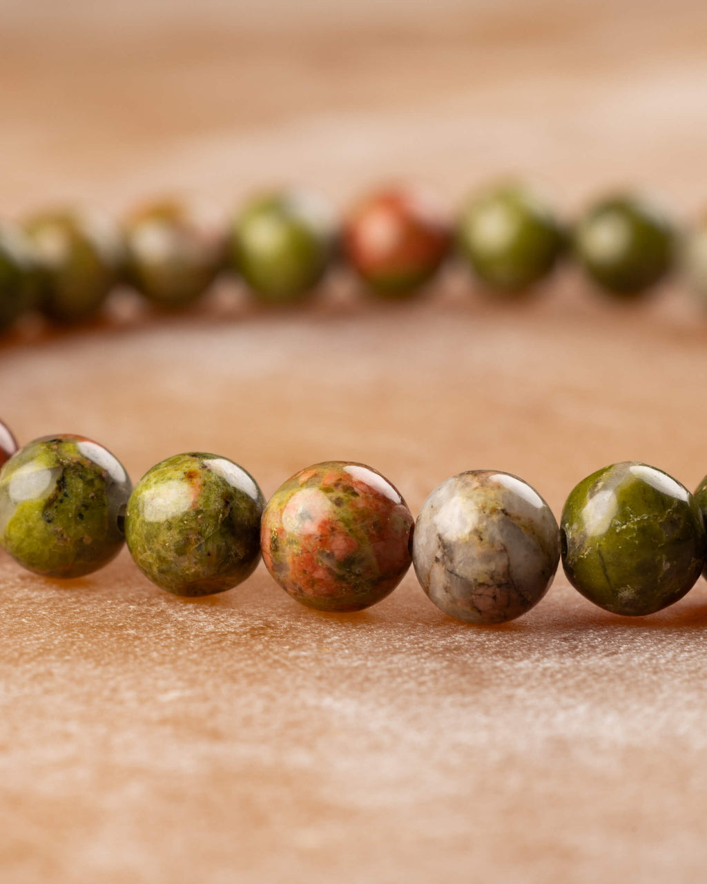 Pulsera de Jaspe Unakita en angulo bajo, cuentas verdes y naranjas alineadas