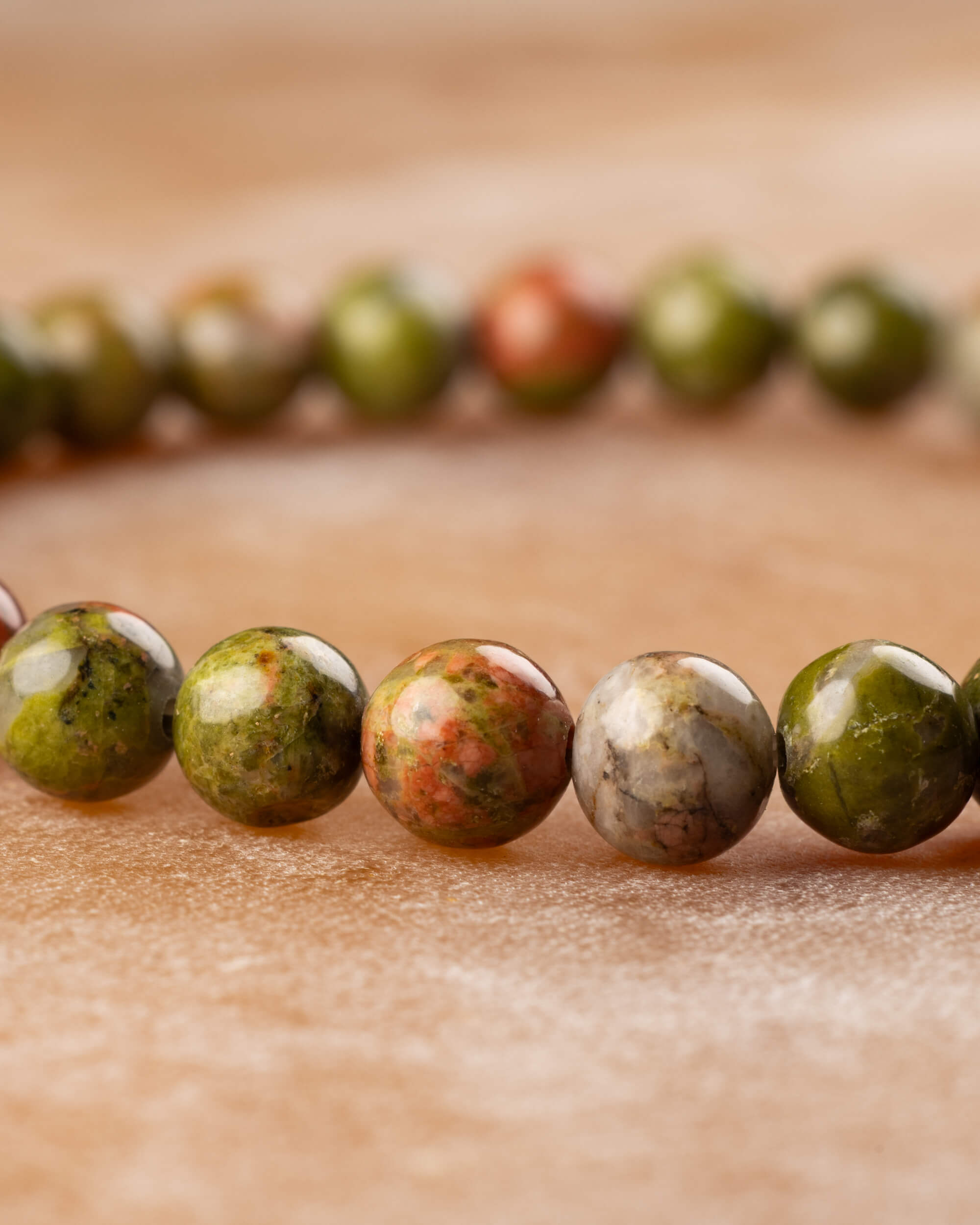 Pulsera de Jaspe Unakita en angulo bajo, cuentas verdes y naranjas alineadas