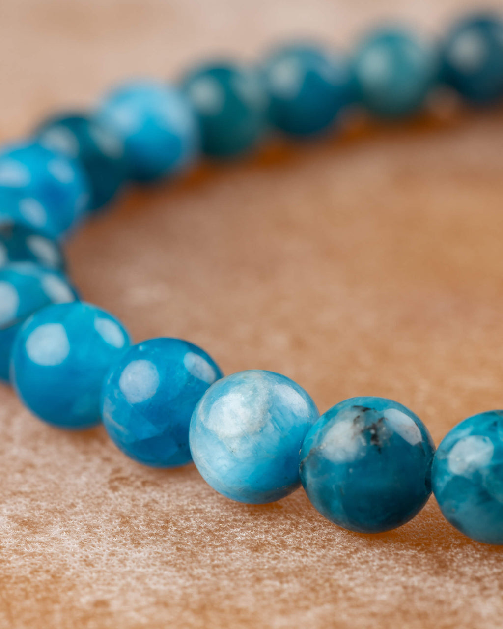 Cuentas de Apatita Azul vistas en ángulo, curva de la pulsera visible